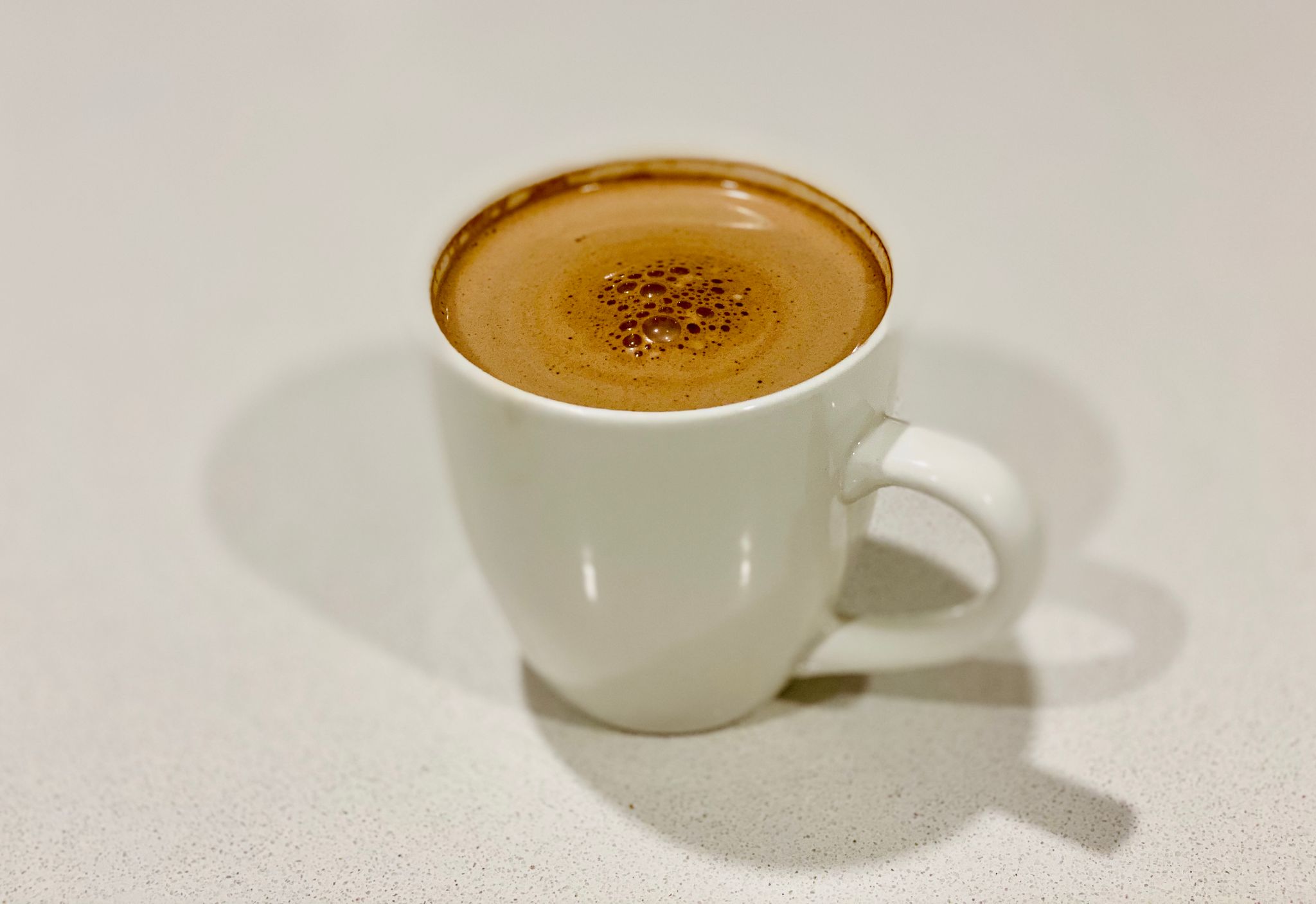 A photo of a white mug with hot chocolate in it.