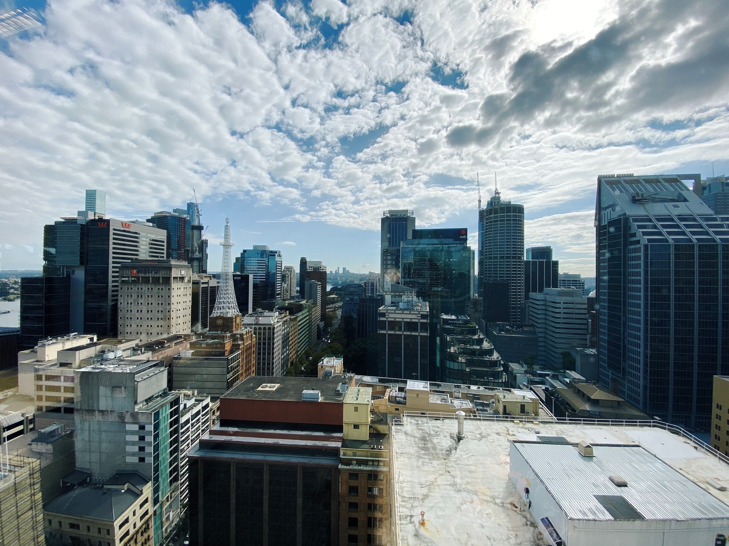 A photo of a cityscape with lots of tall buildings. It's taken from the 22nd floor so above lots of buildings but also with some of the tall buildings above us.