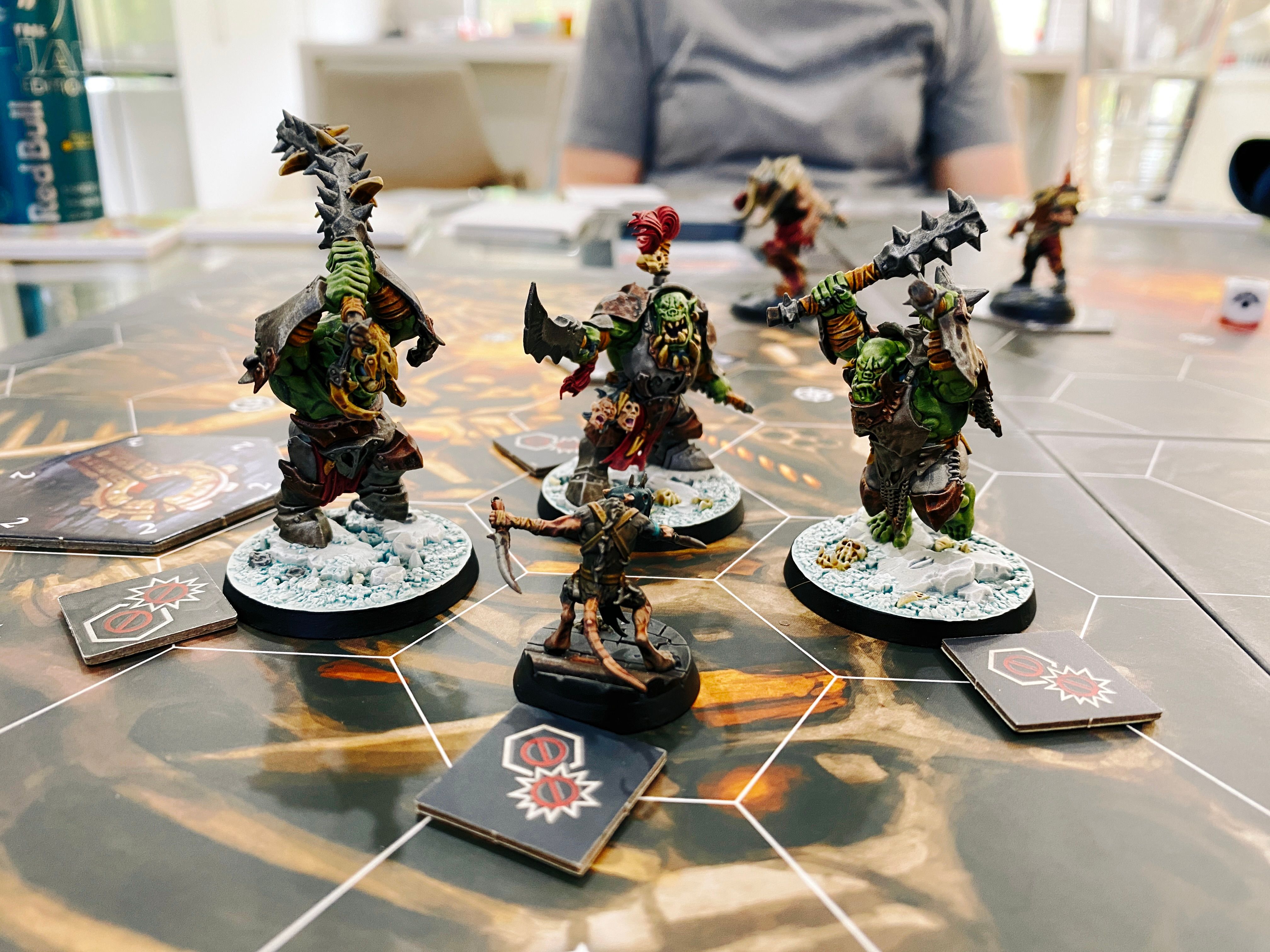 A closeup photo of one of my little Skaven surrounded by the three orks of the Krushas that are absolutely looming over him.