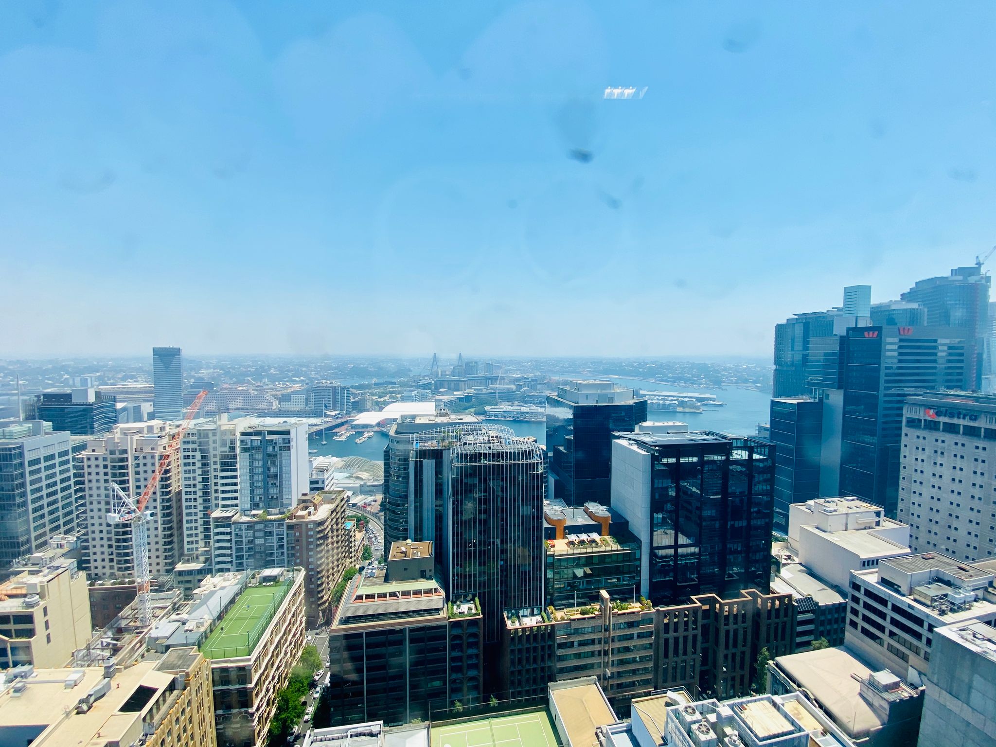 A view from the 29th floor of a building looking out towards the west of Sydney. Some tall buildings are at the right, and smoke haze covers the whole scene.