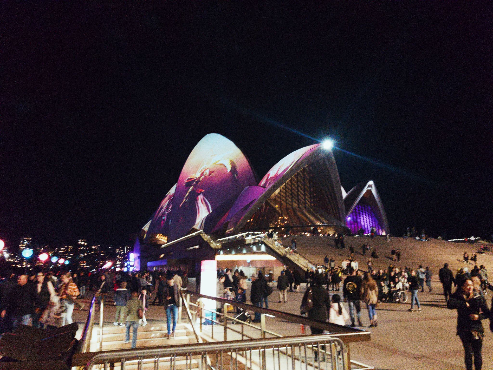 A view of the Sydney Opera House with a purple design being projected onto it.