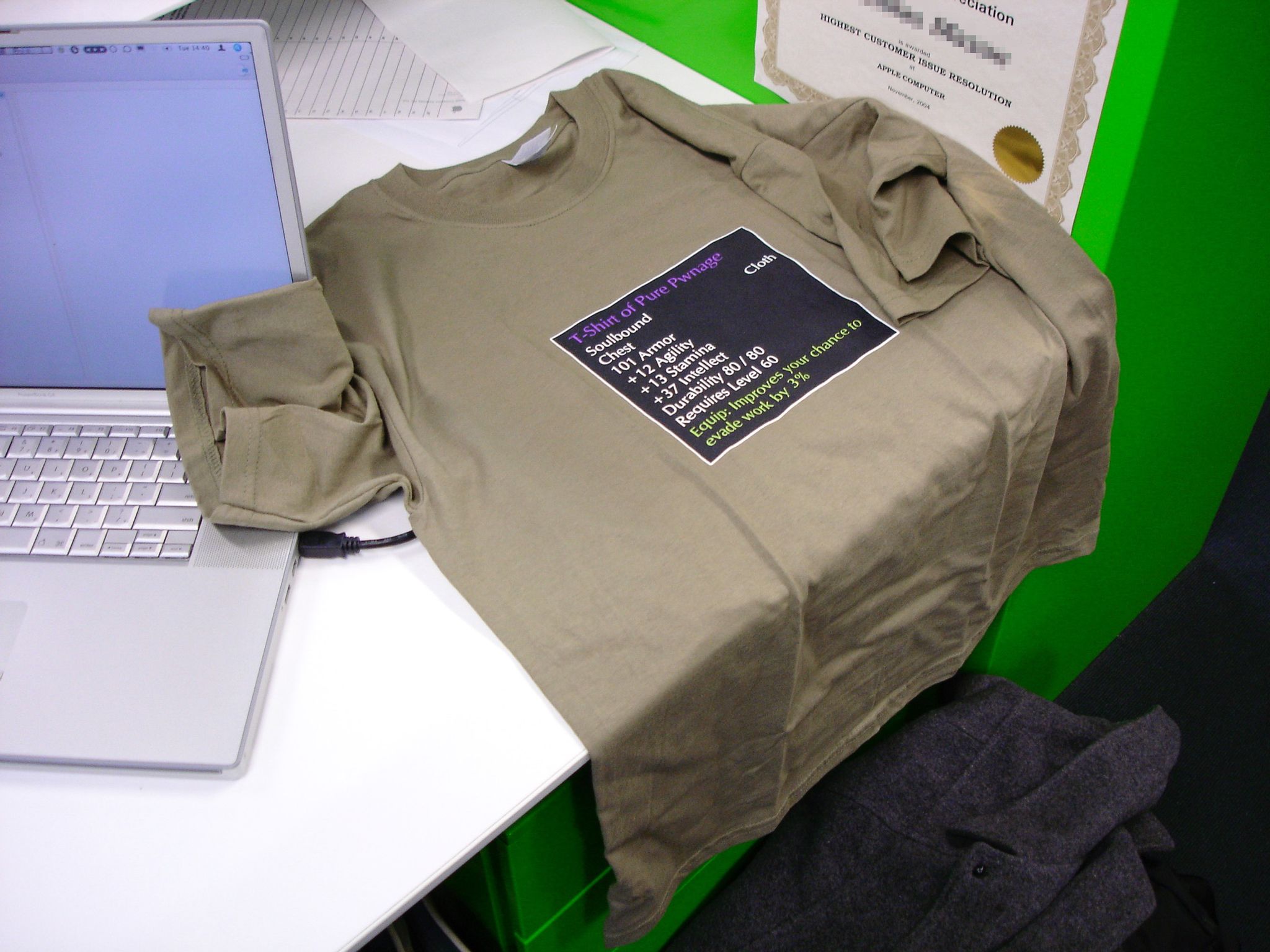 A photo of a t-shirt with a World of Warcraft item stats box on the front of it. It says "T-Shirt of Pure Pwnage", it's a cloth soulbound chest piece, and as well as the normal stats an item has, it says "Equip: Improves your chance to evade work by 3%".