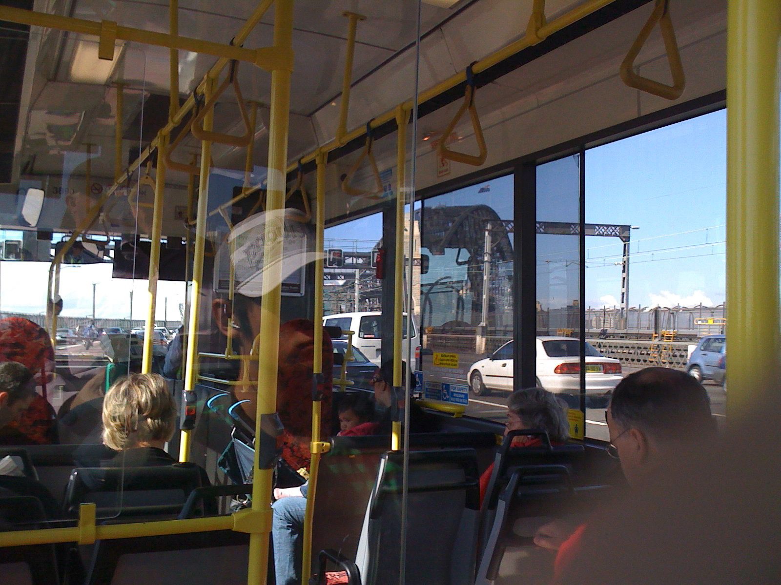 A photo taken from inside a bus looking out the opposite side where the arch of the Sydney Harbour Bridge is just visible.