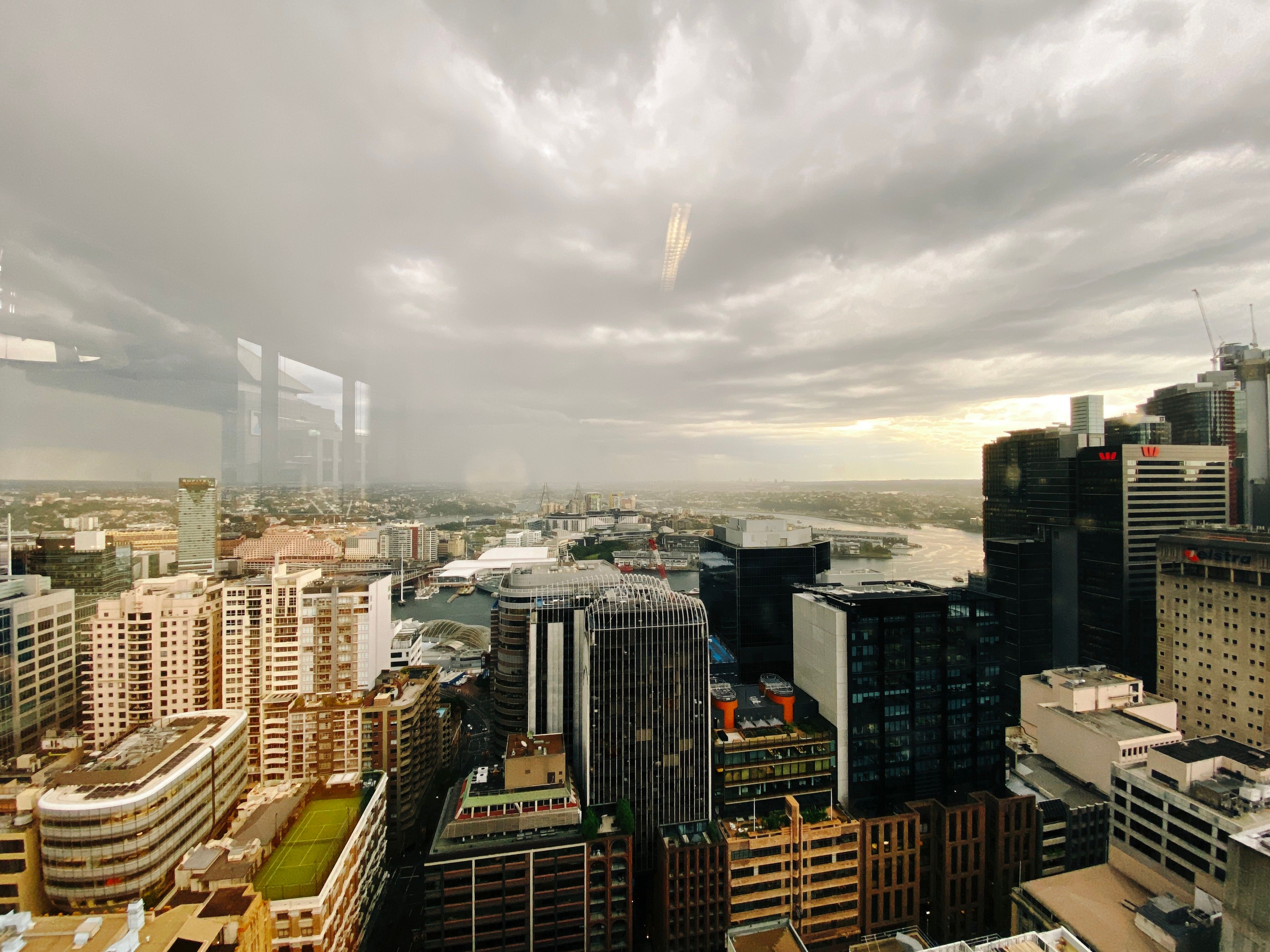 A view looking out west over Sydney from the 30th floor of our office building. The sky is very cloudy and angry-looking, and it's bucketing down with rain in the distance.