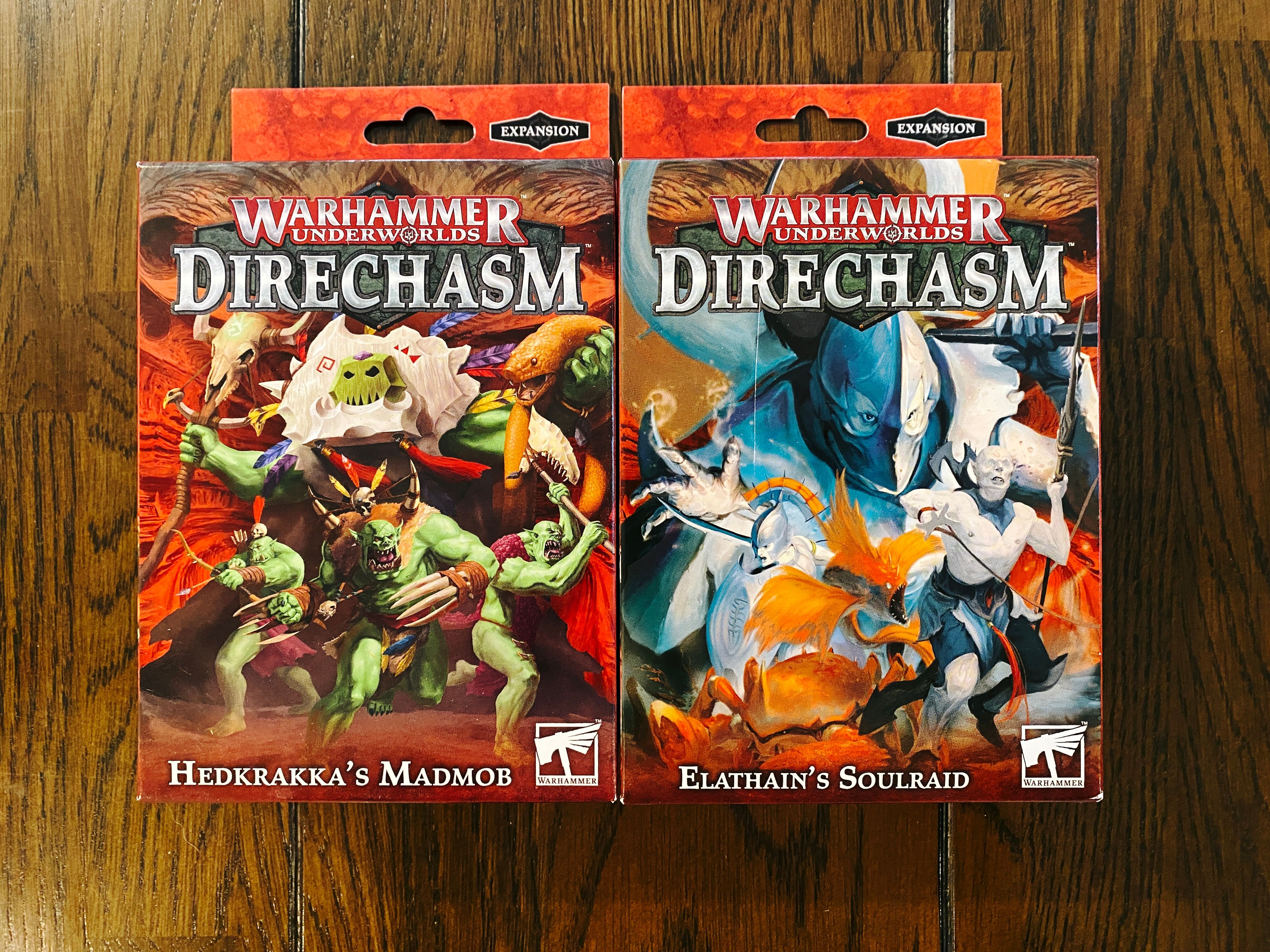 A photo of the boxes of two miniature sets for Warhammer Underworlds. Hedkrakka's Madmob is a tribe of green orcs with loinclothes and basic but savage-looking weaponry, and Elathan's Soulraid are a group of extremely pale elves who live underwater.