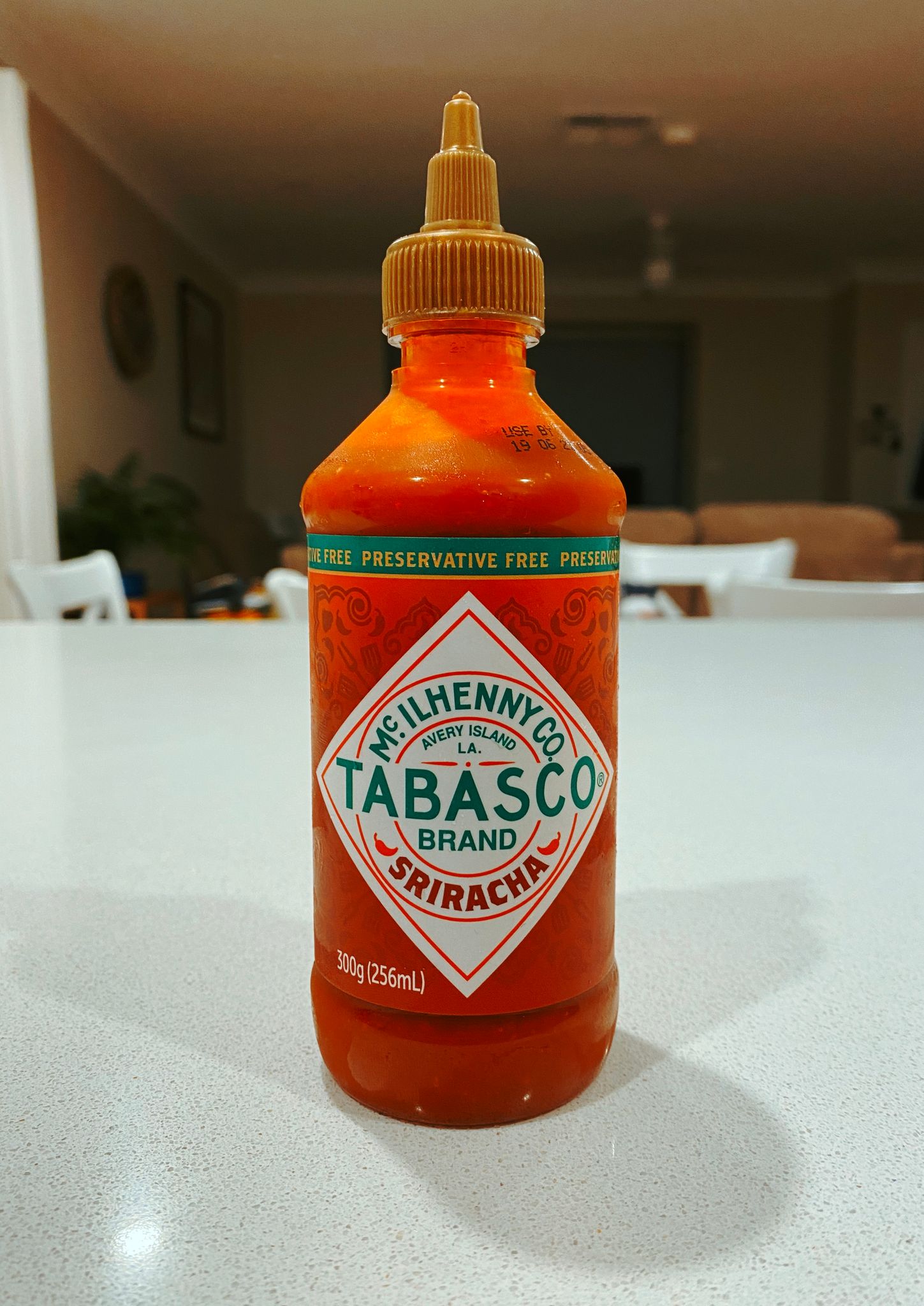 A medium-sized plastic bottle of Tabasco-brand sriracha chilli sauce.