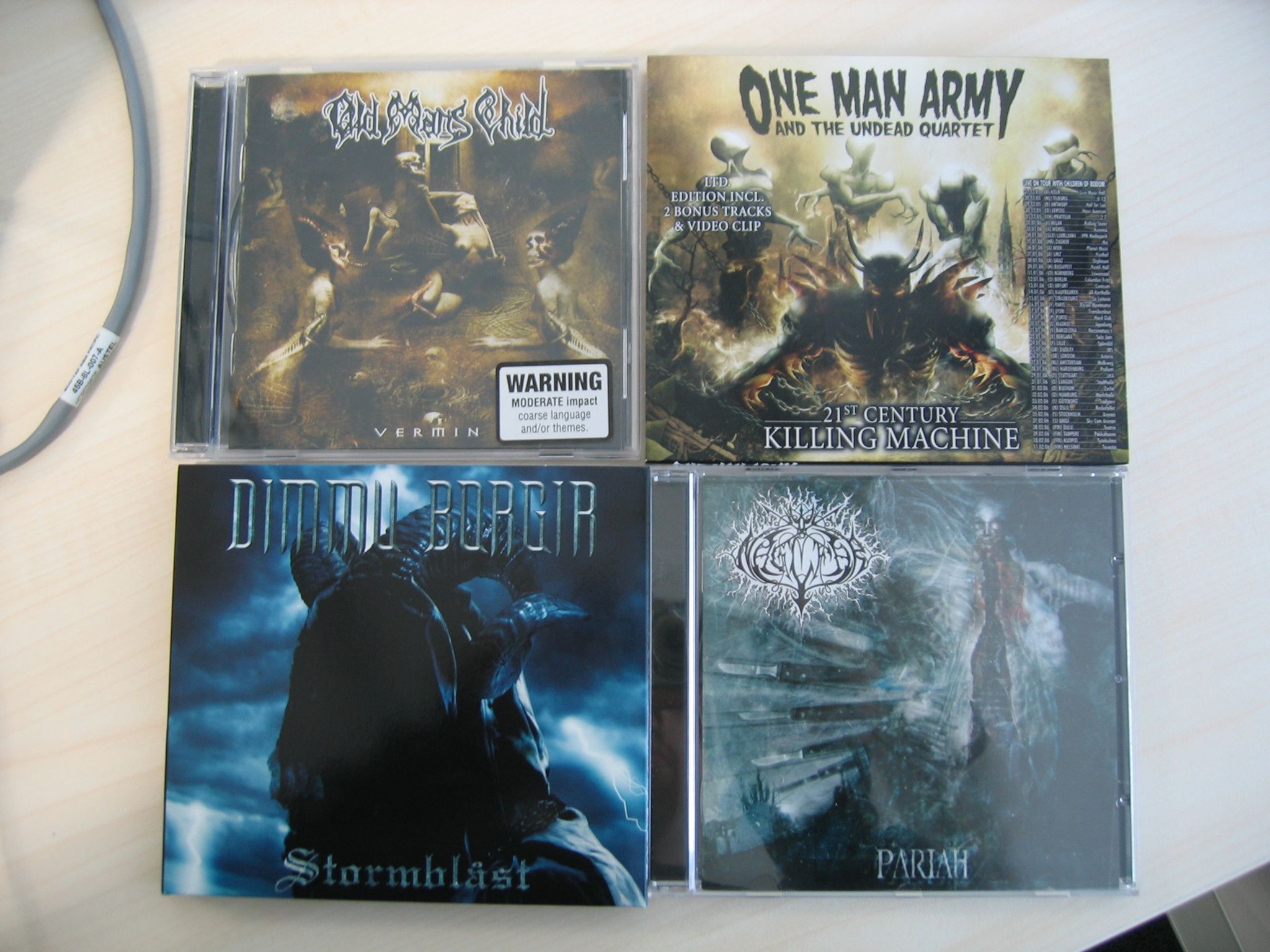 A photo of four CD jewelcases. The albums are Old Man's Child's "Vermin", One Man Army and the Undead Quartet's "21st Century Killing Machine", Dimmu Borgir's "Stormblåst", and Naglfar's "Pariah".