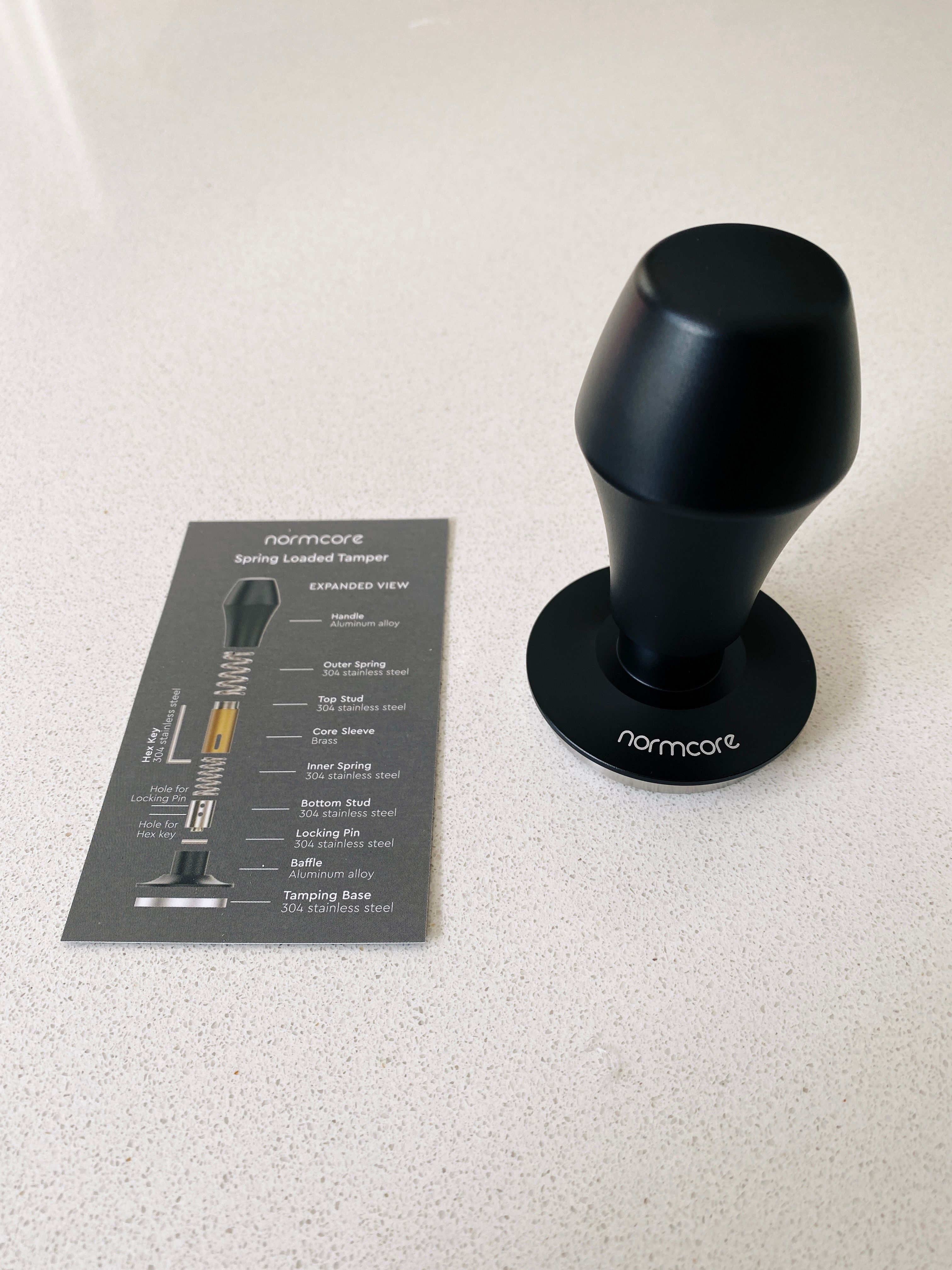 A photo of a black "Normcore" brand (yes, really) espresso tamper. It looks kind of alarmingly like a butt plug tbh.