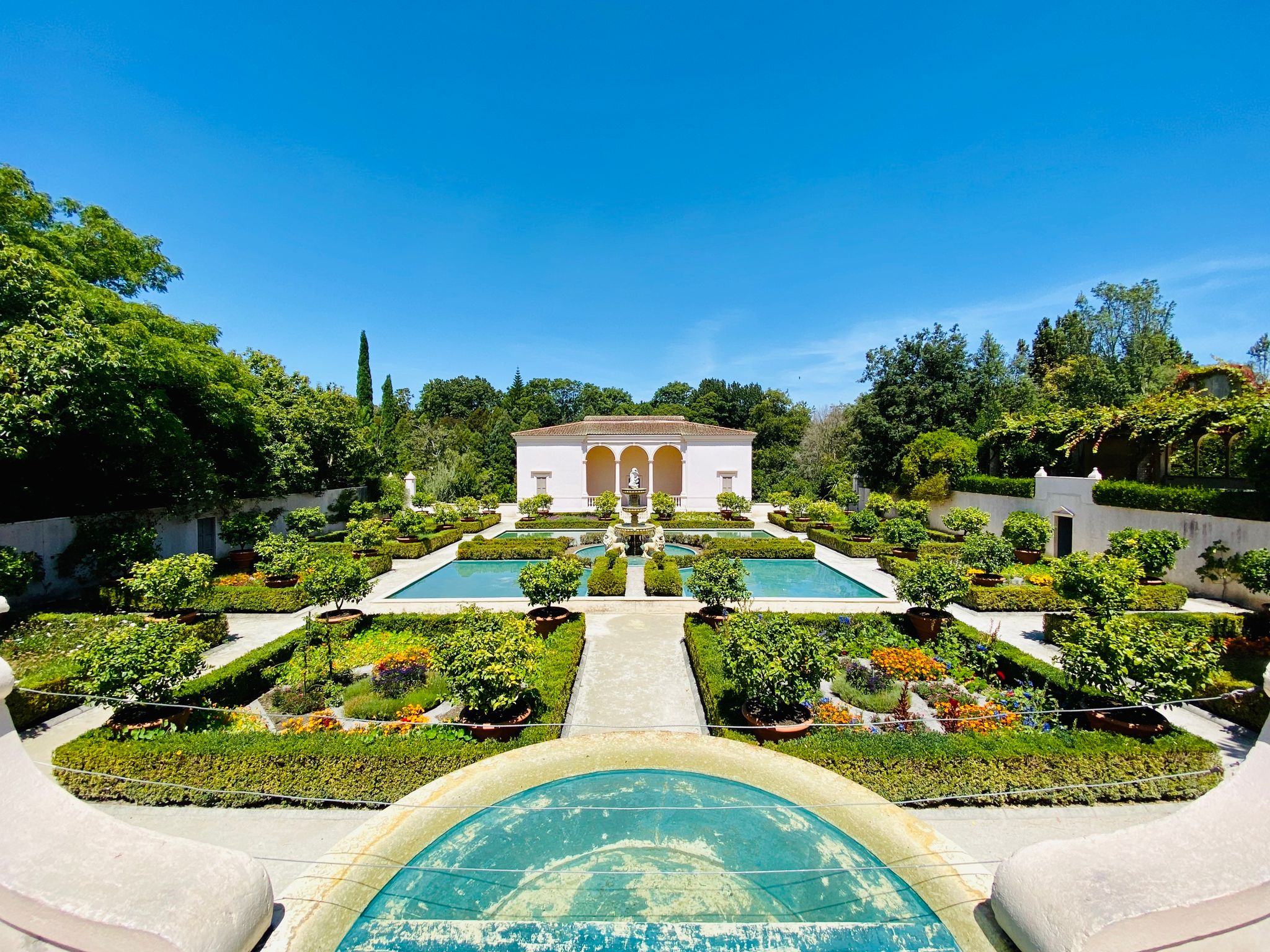 A photo of a quite large garden done in an Italian Renaissance style, with marble and statues and greenery.