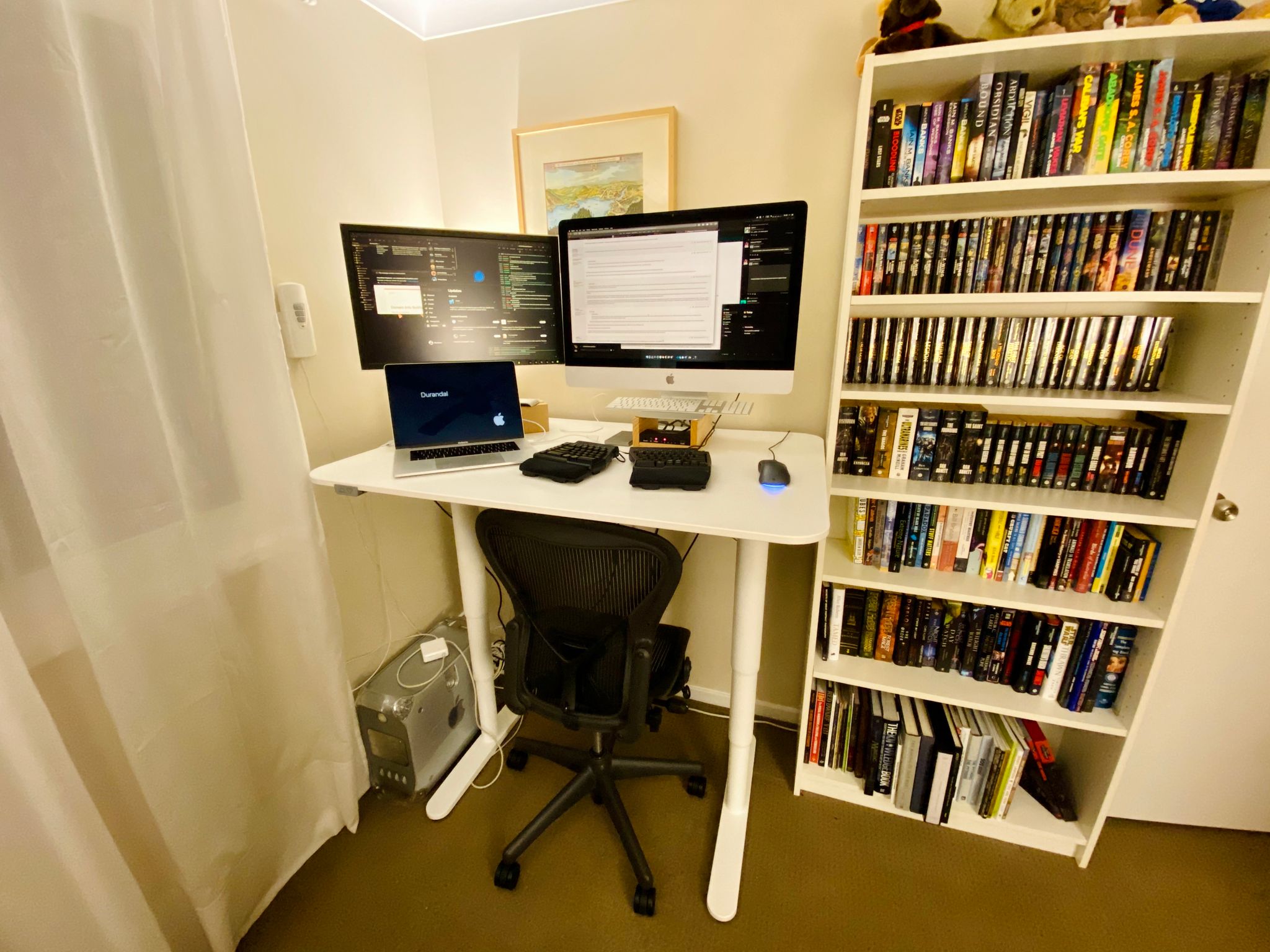 Another photo of the room with the same setup as the first photo except the desk is now a standing desk and is at its full standing position.