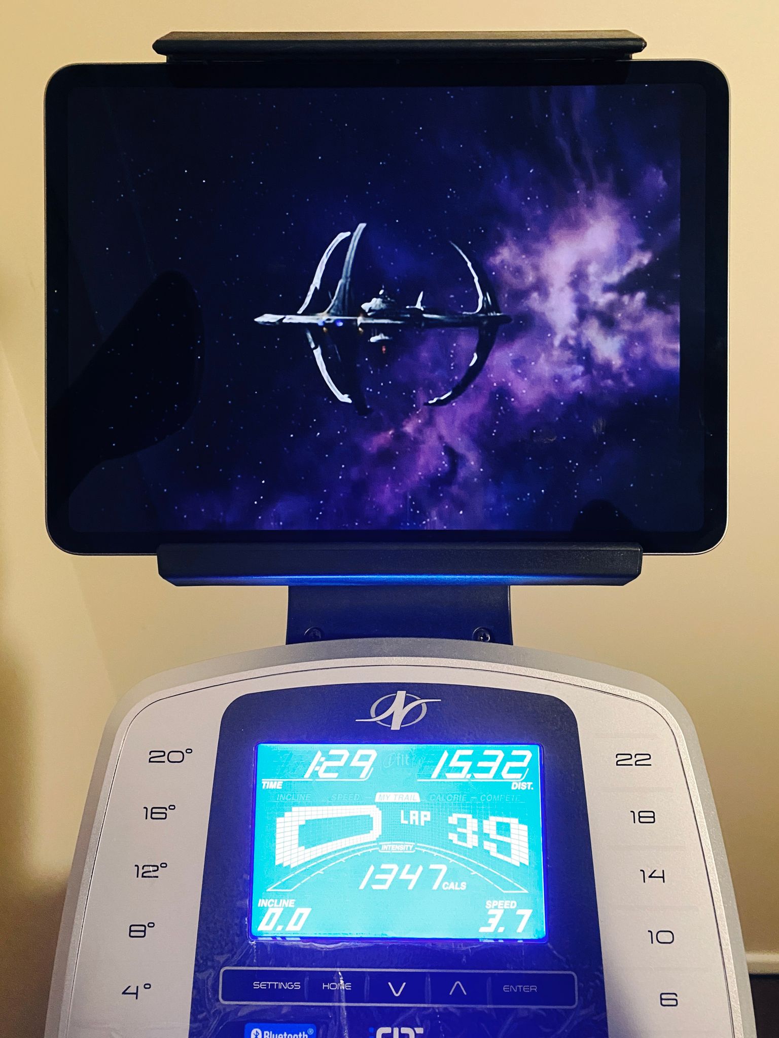 A photo of the elliptical showing 1349 calories burnt in an hour twenty-nine, and the iPad is paused at the very end of the last episode of Deep Space Nine, with the station itself slowly receding into the distance and a deep purple nebula behind it.
