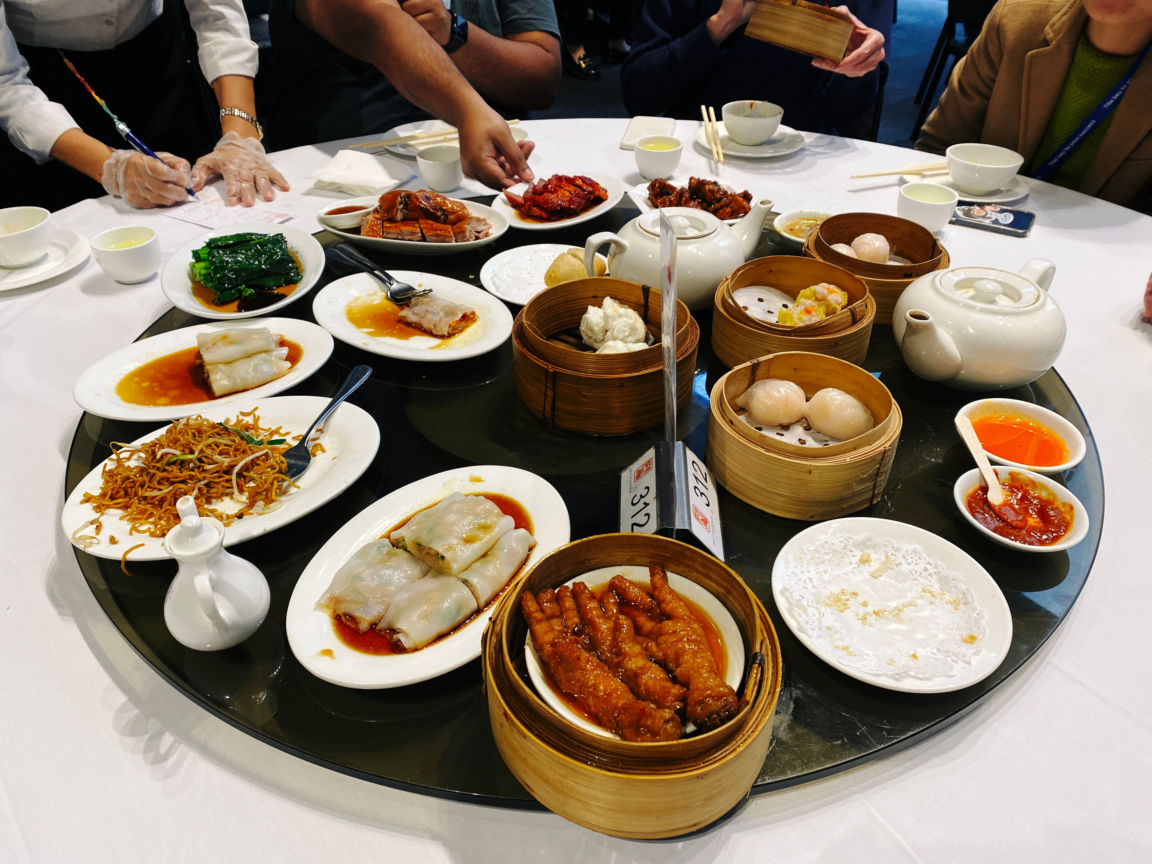A photo of a big lazy susan with all sorts of delicious Chinese food on it: dumplings, pork buns, noodles, chicken feet, etc. (I did not have any of the chicken feet.)