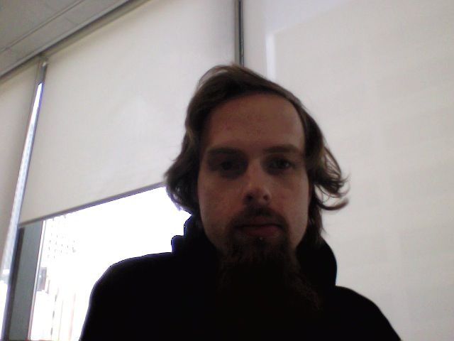 A photo of me, a white man with long hair and a goatee taken with Photo Booth on a Mac laptop. 