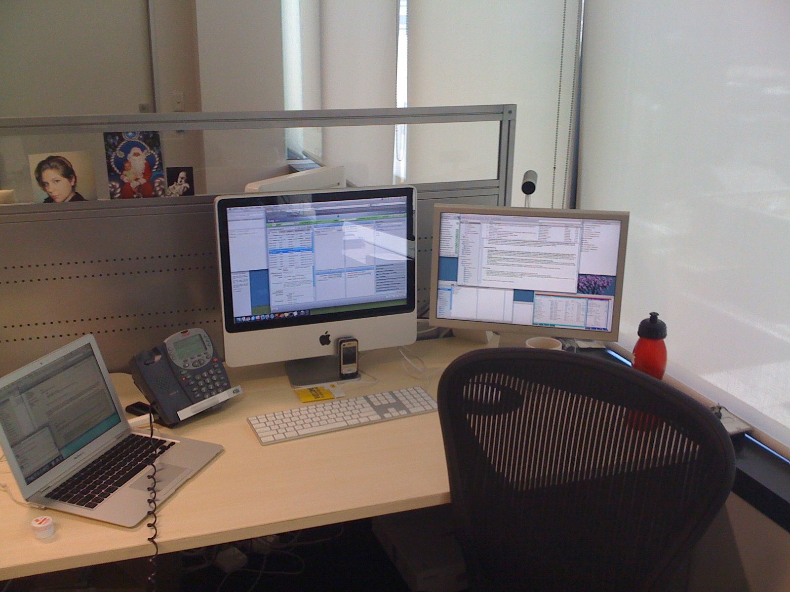 A photo of my work desk setup. The iMac is in the middle, Cinema Display to the right, and MacBook Air to the left, with a call centre desk phone sitting between the iMac and the MacBook Air.