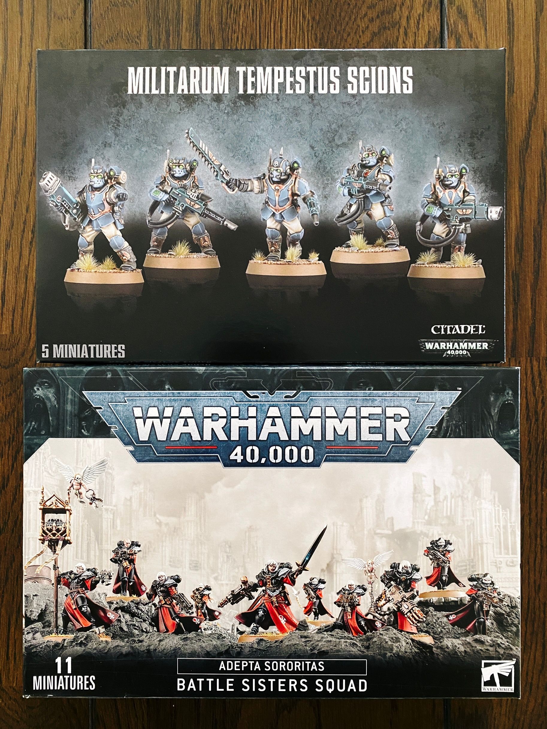 A photo of the box of five Astra Militarum Scions (heavily-armoured troopers carrying a variety of special weapons) and a box of ten Battle Sisters, who are the military arm of the Imperial Church in Warhammer 40,000 and as the name suggests are all women. They look very striking, the armour is black, with red cloaks, and they all have pure white hair with bob haircuts.