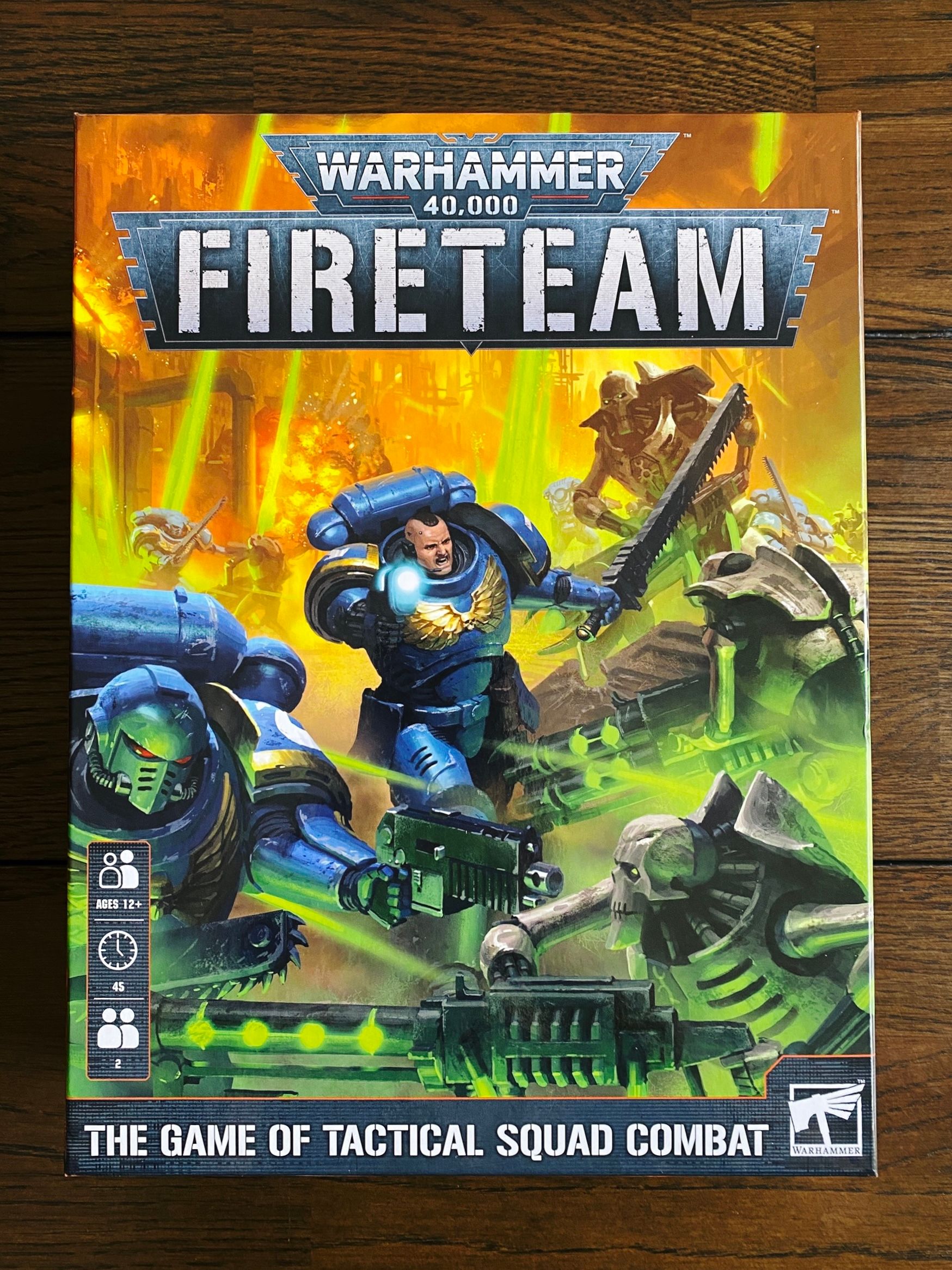 A photo of the box of Warhammer 40,000: Fireteam. The artwork consists of two Space Marines clad in blue power armour in the midst of a number of grey metal Terminator-looking robots.
