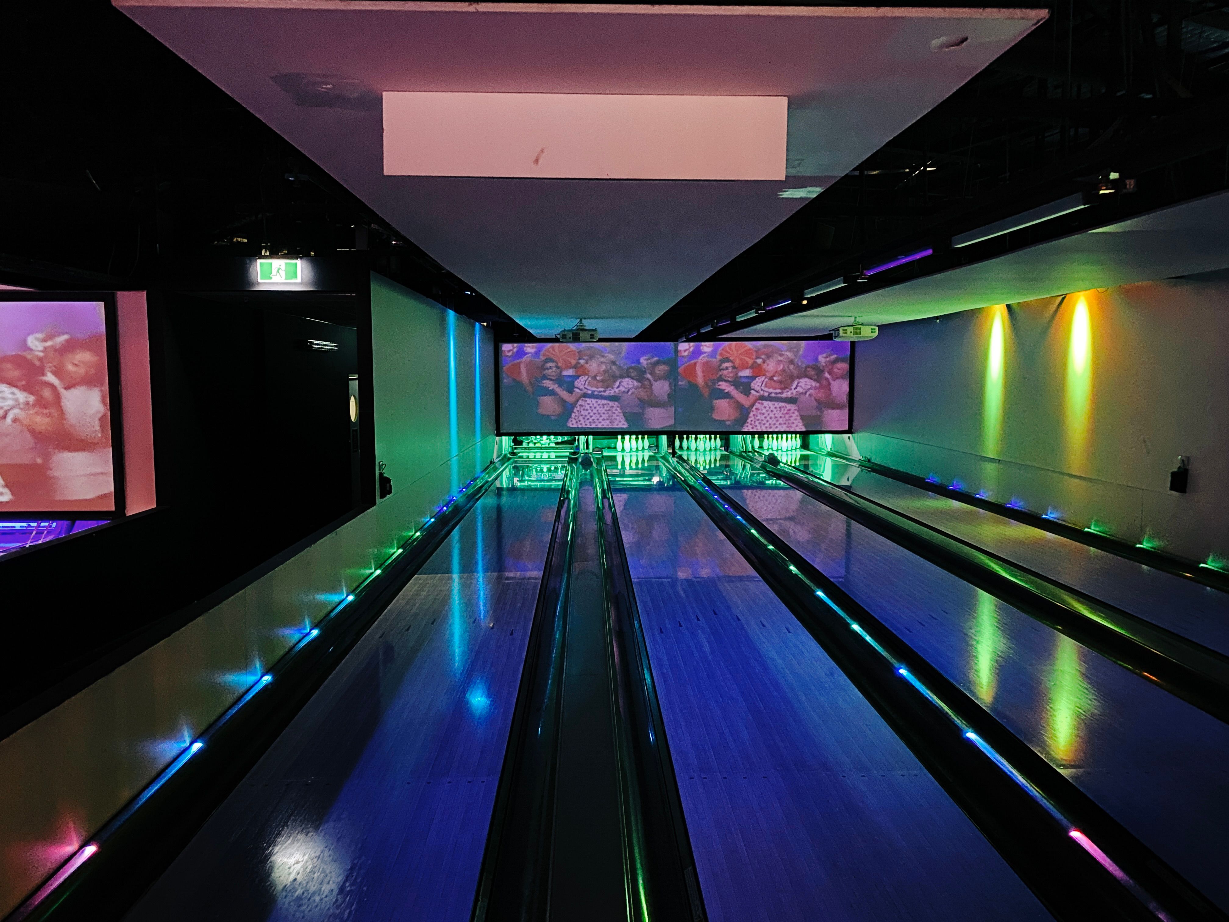 A photo looking down the middle of two lanes of a bowling alley.