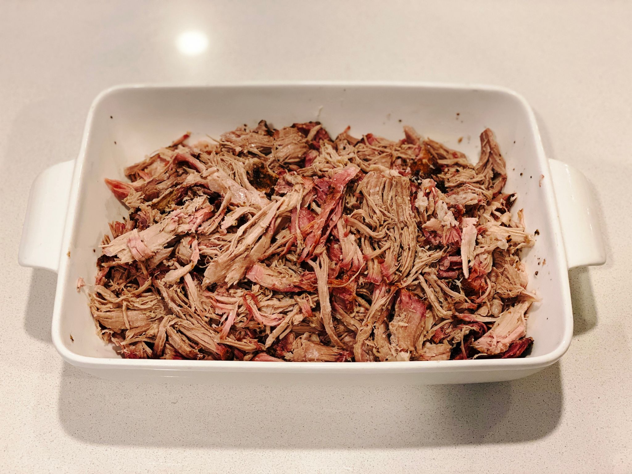 A photo of the now-pulled pork in the ceramic dish. It looks (and was) DELICIOUS.