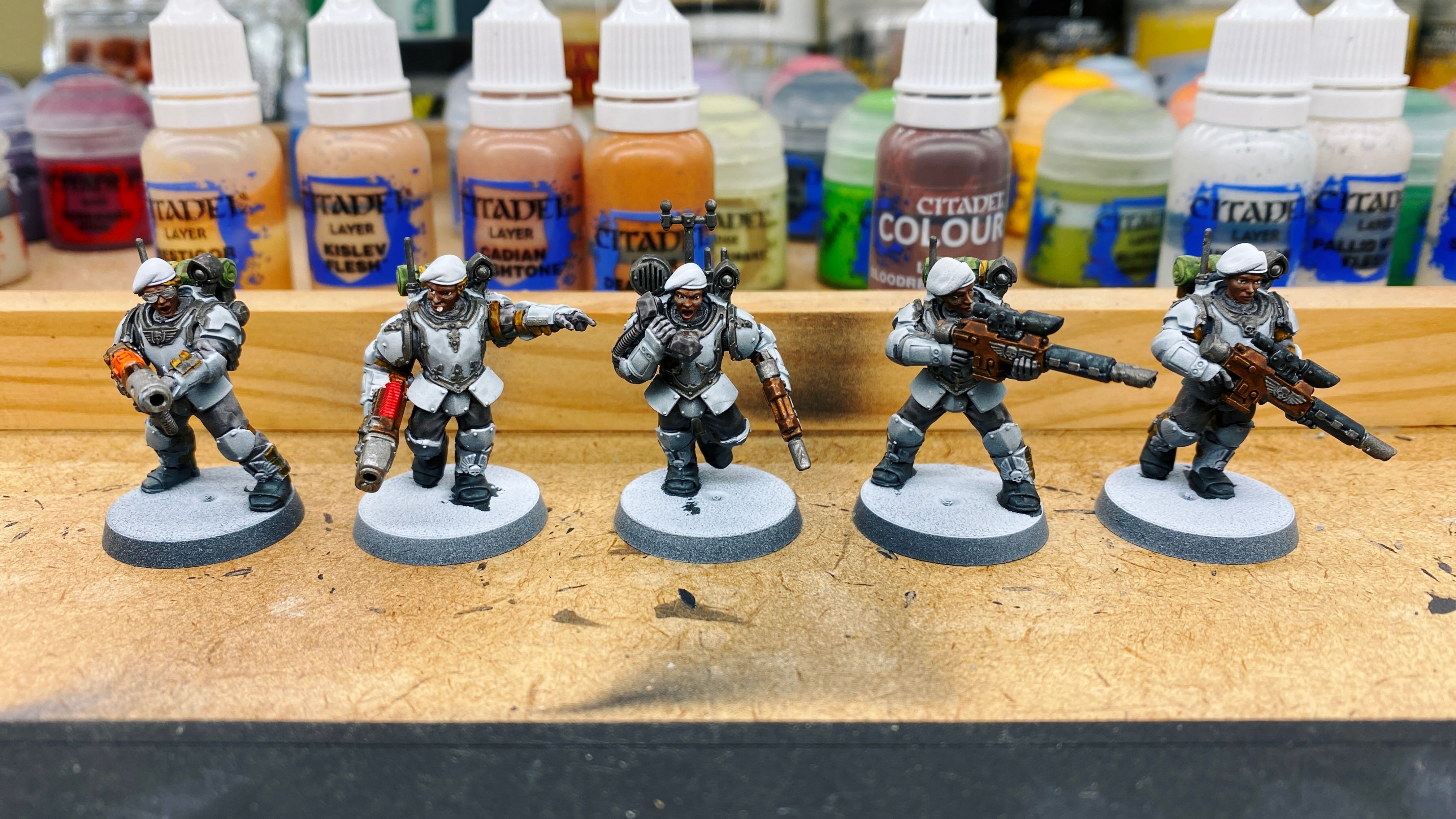 A photo of five mostly-painted armoured troops. They've got light blue/grey armour and are all holding futuristic-looking guns. Their faces are brown with nice highlighting and I managed to do the eyes including the pupils.