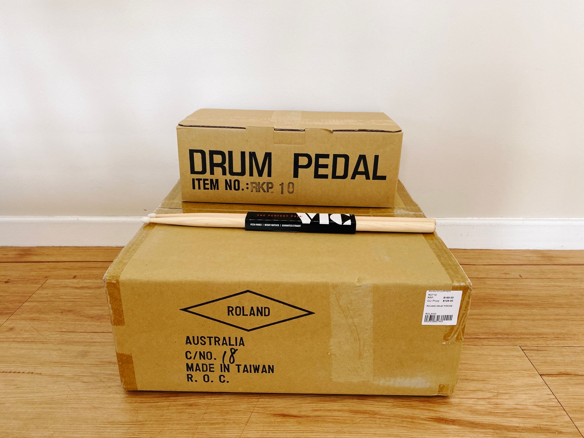 A photo of two cardboard boxes and a pair of drum sticks.